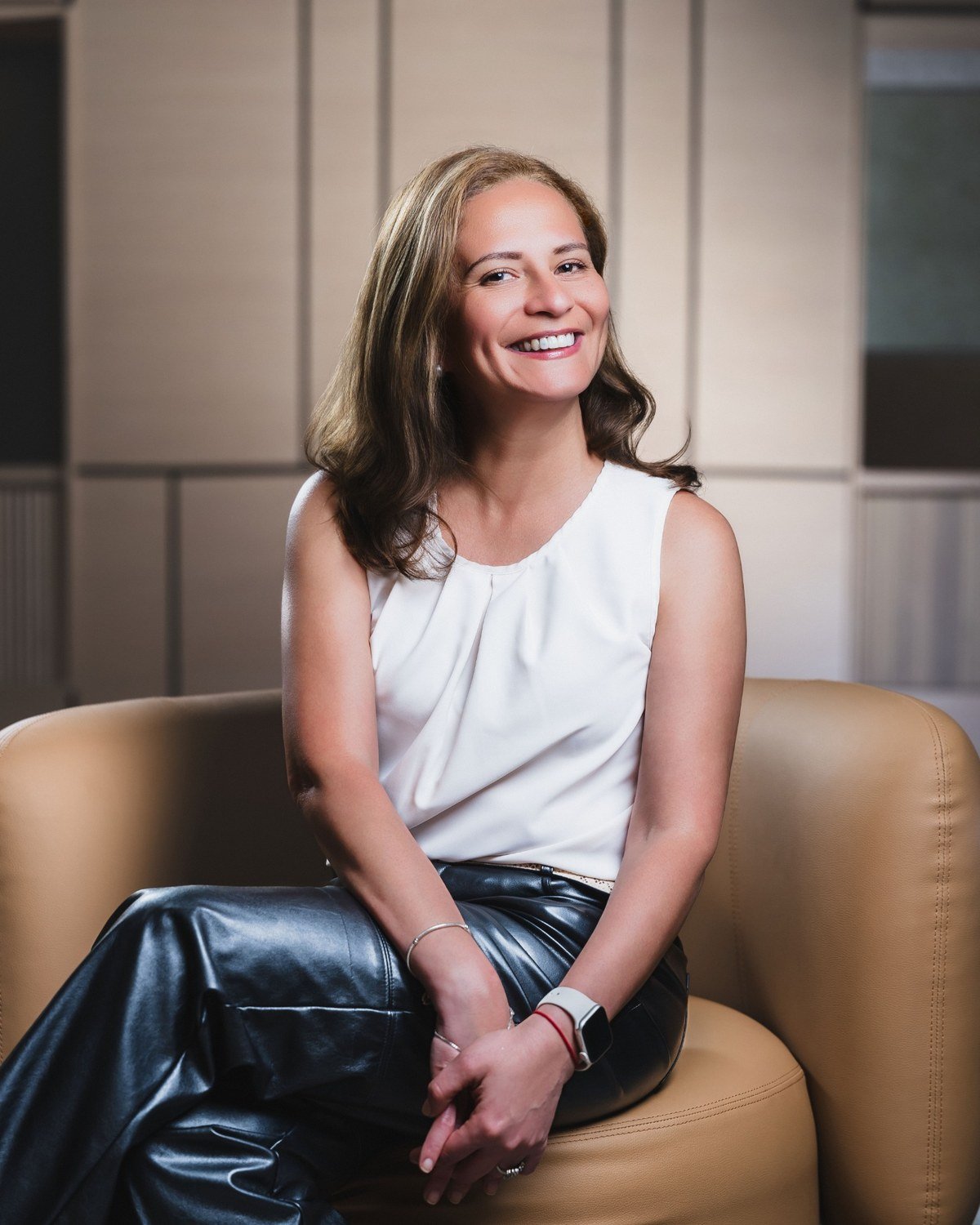Maria Fernanda Crespo sentada en un espacio contempor&aacute;neo, sonriendo a la c&aacute;mara